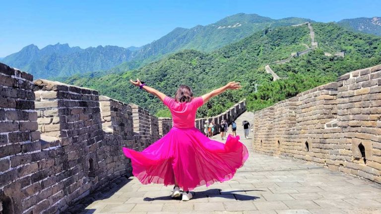 We Slept Inside A Great Wall Watchtower: A 2-Day Jinshanling, Gubeikou &Amp;Amp; Mutianyu Trip Woman In Pink Dress Standing On The Great Wall At Mutianyu With Arms Outstretched, Mountains And Wall Stretching Into The Distance