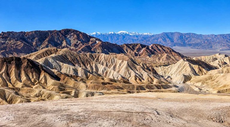Golden Badlands And Layered Desert Ridges At Zabriskie Point In Death Valley National Park.